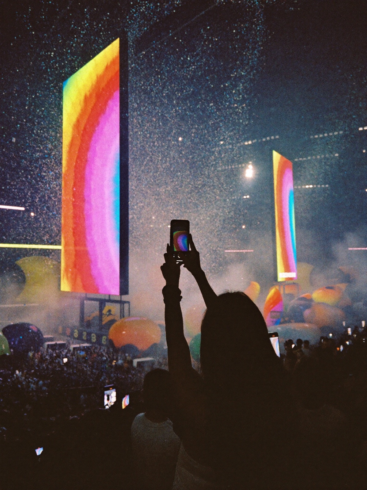 Creator filming a massive brand activation, confetti and giant screens